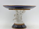an image of a blue and white plate with a statue on it