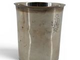 an old silver cup with a handle on a white background