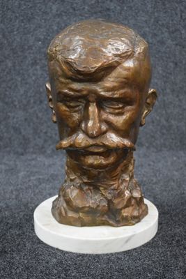 bronze bust of a man with a mustache and moustache on a marble base