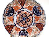 an orange and blue plate with a flower design on it