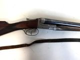 an old gun with a wooden handle and a sling on a white surface
