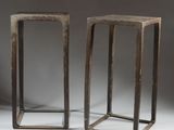 a pair of wooden stools with metal legs on a grey background