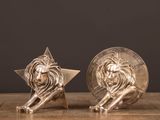 une paire de serre-livres en forme de lions en argent posés sur une table en bois