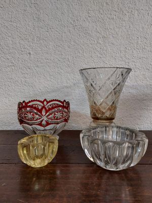 plusieurs bols et tasses en verre posés sur une table en bois, avec un mur blanc en arrière-plan
