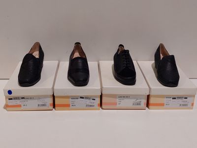 trois paires de chaussures noires posées sur des cartons, sur une surface blanche