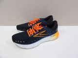 a pair of black and orange running shoes on a white surface