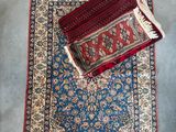 a blue rug with a red and white rug on top of it