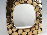 an image of a gold and black square shaped mirror