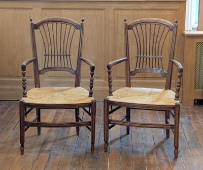 deux chaises en bois assises l'une à côté de l'autre sur un plancher en bois