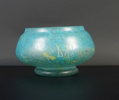 un vase bleu sur lequel figurent des inscriptions, posé sur une table