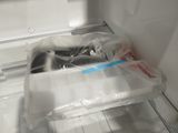 an open refrigerator door with plastic bags in it