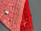 two red and black rugs sitting on top of a gray surface