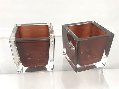 two square glass vases sitting on a white surface
