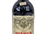 a bottle of red wine sitting on a white surface
