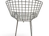 a black wire chair sitting on top of a white floor