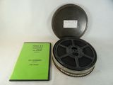 une bobine de film posée sur une table à côté d'un livre