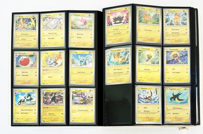 beaucoup de cartes Pokémon dans un classeur posé sur la table