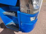 a close up of the front of a blue truck with its door open