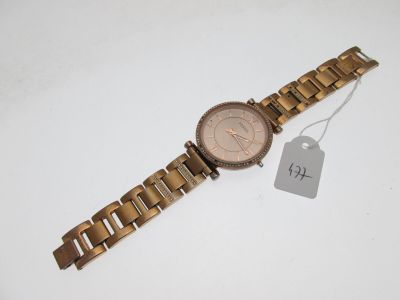 gros plan d'une montre sur une surface blanche avec une étiquette de prix