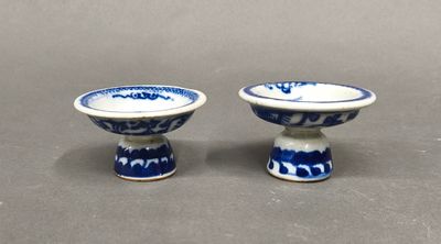 pair of blue and white porcelain bowls on pedestals on a table