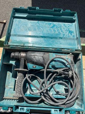 une boîte contenant une perceuse et une cordelette