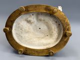 an image of a gold plate with holes on it on a gray surface