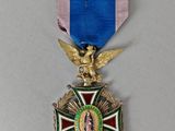 une image représentant une médaille ornée d'un ruban bleu et d'un aigle doré