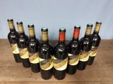 six bottles of wine are lined up in a row on a wooden table