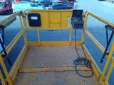 a small yellow platform with a phone on it in the middle of a parking lot