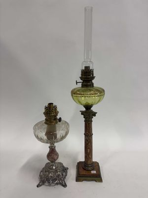 une paire de lampes à huile anciennes et une lampe en verre posée sur un pied