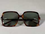une paire de lunettes de soleil posée sur une surface blanche
