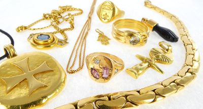 a lot of gold jewelry on a white surface