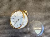 une petite horloge posée à côté d'une boule de verre sur une table