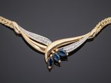 a yellow gold necklace with a blue sapphire and diamonds