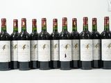 six bouteilles de vin sont alignées sur une surface blanche