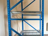 a blue shelf in a room with a radiator in the corner