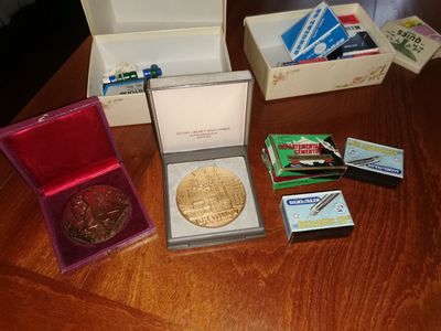 une table en bois sur laquelle sont posés un paquet de cartes et une médaille d'or