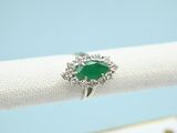 a close up of a ring with a green stone on it