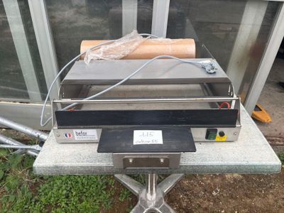 un hot-dog posé sur une table devant une porte vitrée