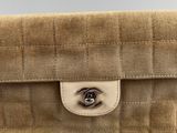a chanel beige quilted clutch bag with a metal clasp