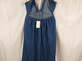 the back of a blue denim jumpsuit with straps on a hanger