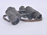 an old pair of binoculars sitting on top of a white surface