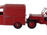 un camion rouge miniature avec un homme dans la cabine