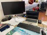 un bureau sur lequel se trouvent un ordinateur, un clavier, une souris et d'autres objets