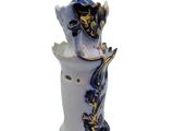 a white vase with a blue and gold decoration on it