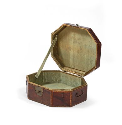 une vieille valise ouverte posée sur une surface blanche