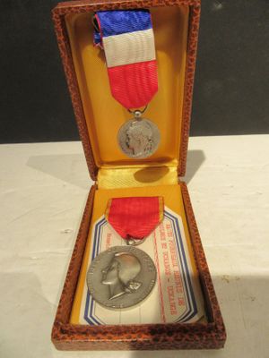 une médaille dans un écrin, entourée d'un ruban
