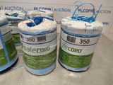 three rolls of blue and green colored thread are on a table