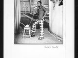 black and white photograph of a man sitting on a chair in a room