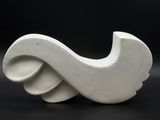 a white sculpture that is sitting on a black surface